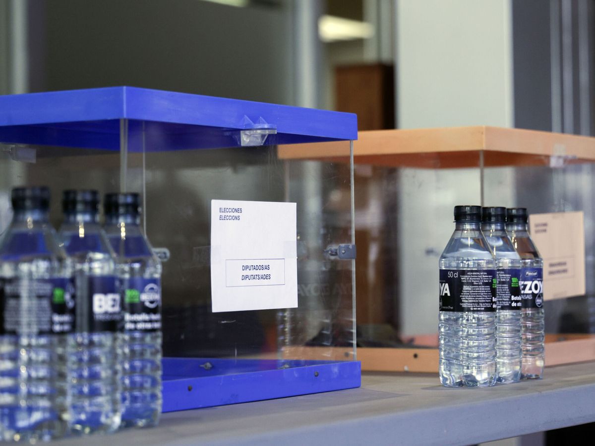 Foto: Detalle de las urnas y las botellas de agua dispuestas para los miembros de las mesas electorales. (EFE/Quique García)