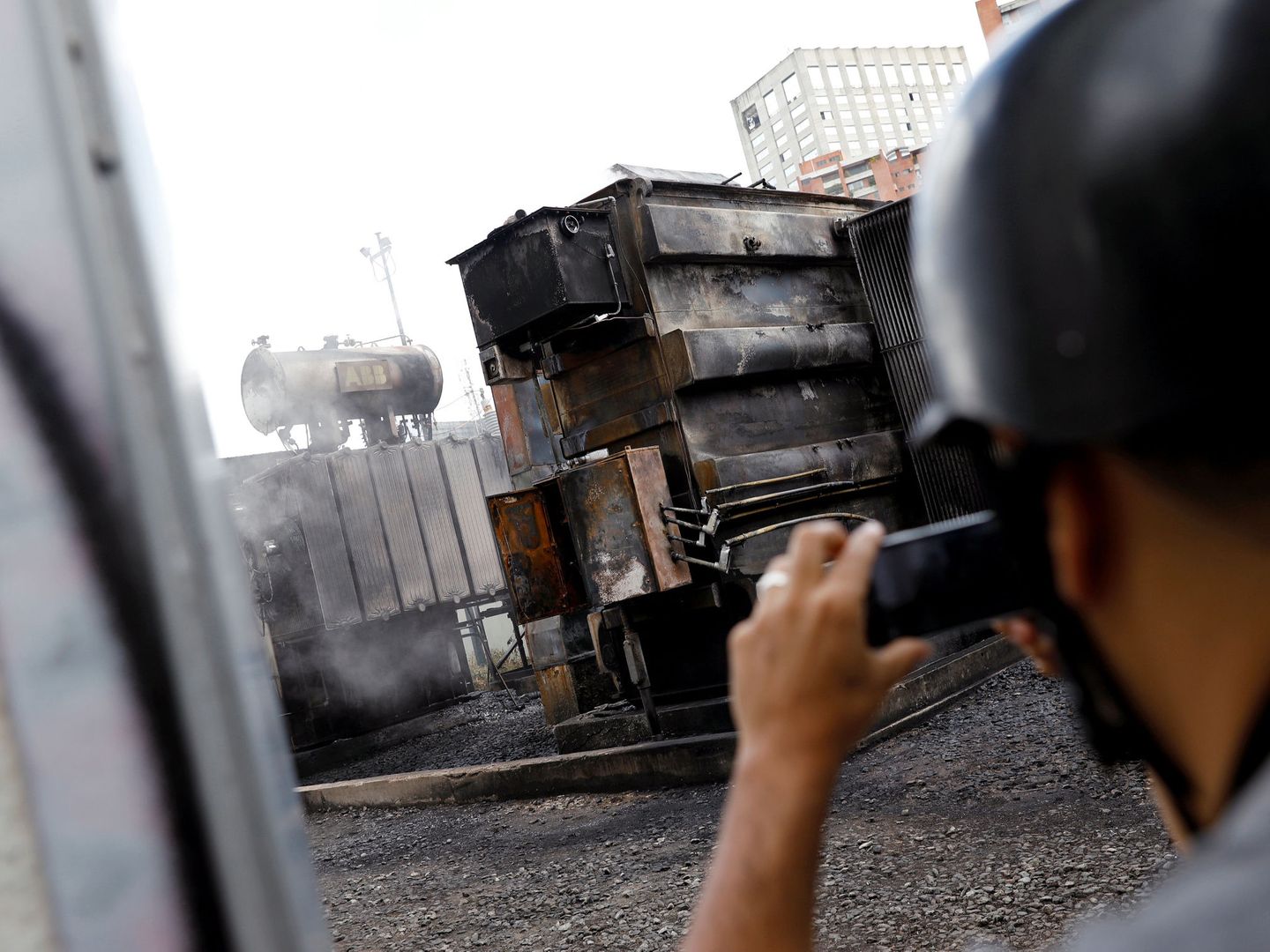 Un hombre hace fotos de una subestación eléctrica quemada en Caracas durante el apagón, el 11 de marzo de 2019. (Reuters)