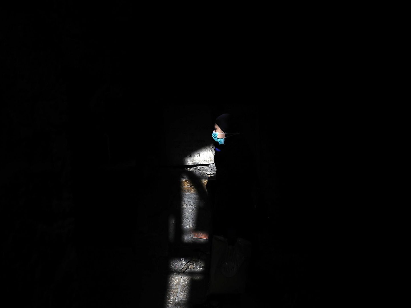 Una mujer camina por Jerusalén llevando una mascarilla. (EPA)