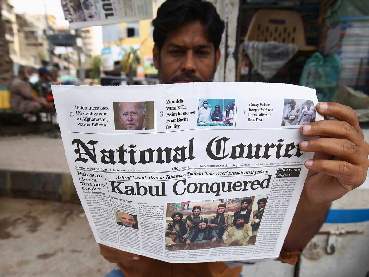 Foto: Un hombre lee el periódico en Pakistán. En el titular: "Kabul, conquistada". (EFE)
