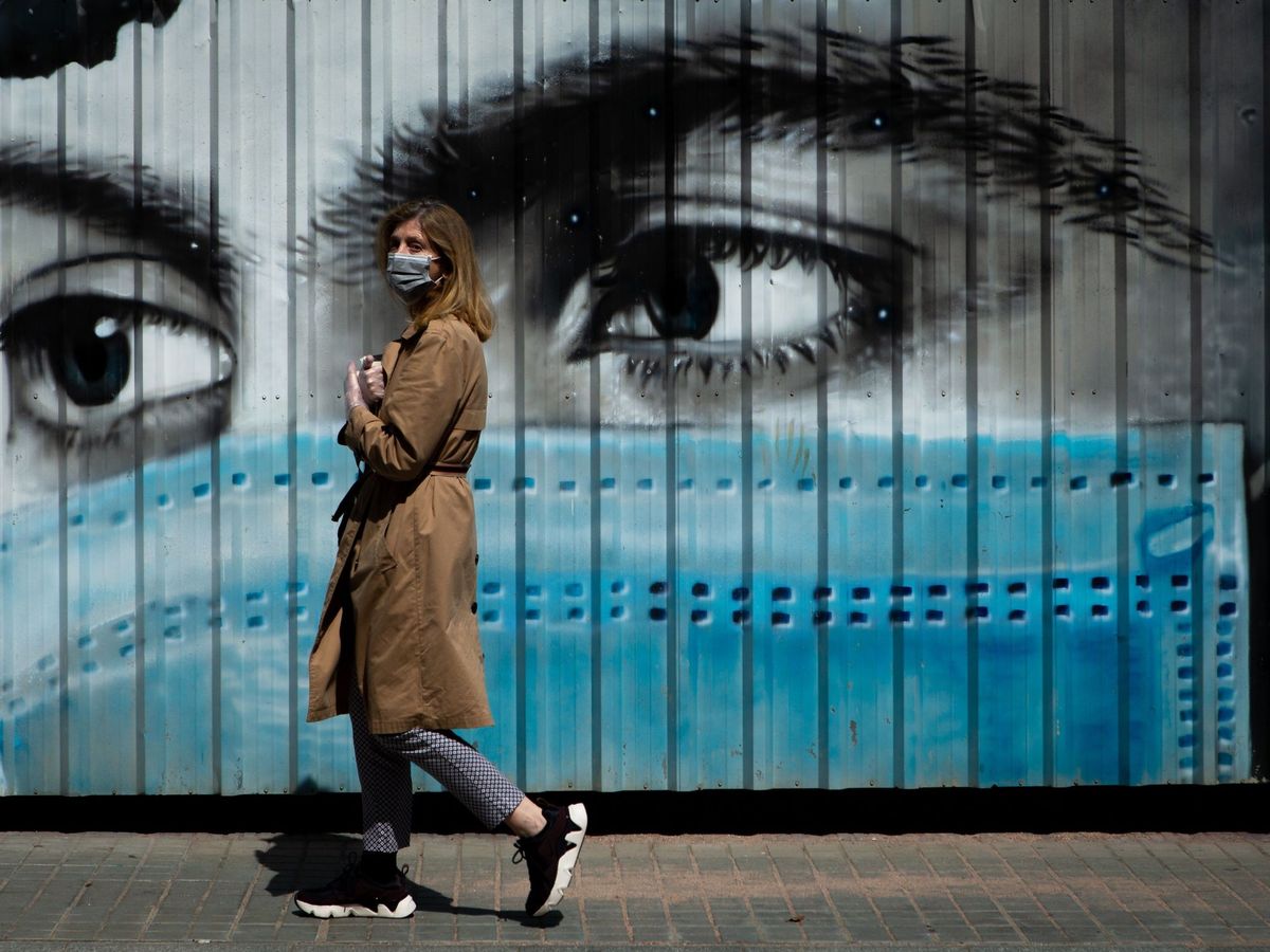 Foto: Una mujer camina ante un grafiti en Barcelona esta semana. 