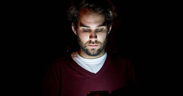 Foto: Joven mirando un móvil por la noche. Foto: Pixabay.