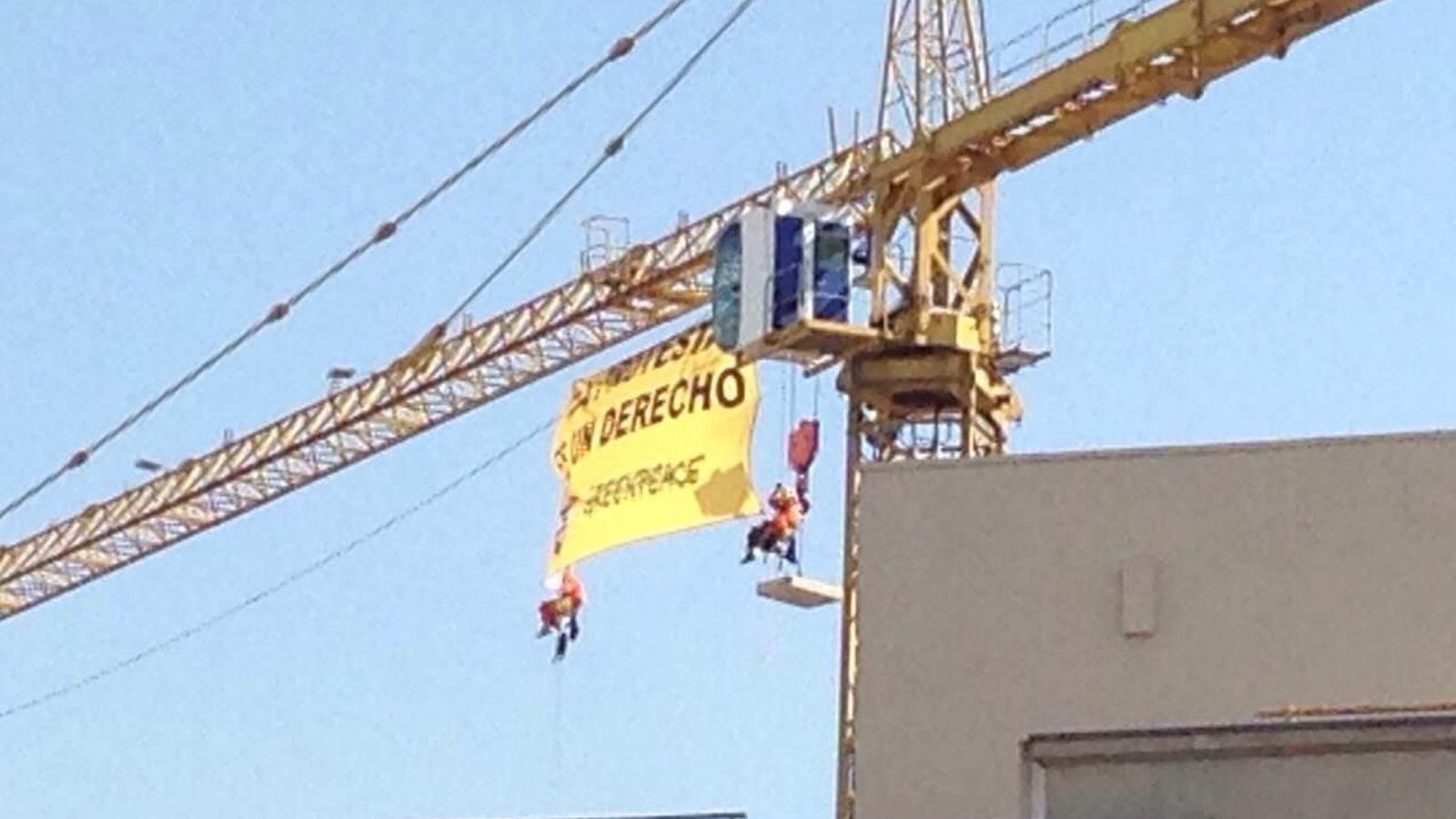 Foto: Activistas de Greenpeace subidos a una grúa cerca del Congreso de los Diputados. (EC)
