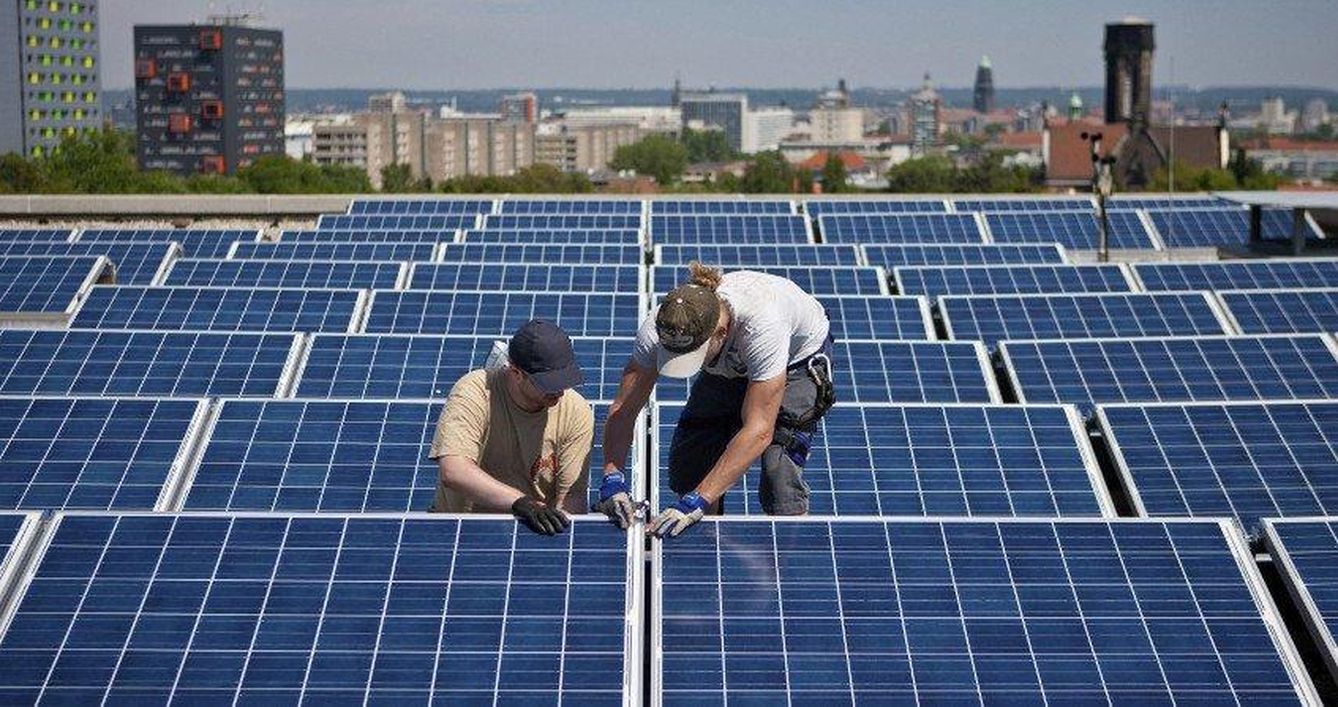 Trabajadores instalando paneles solares. (EFE)