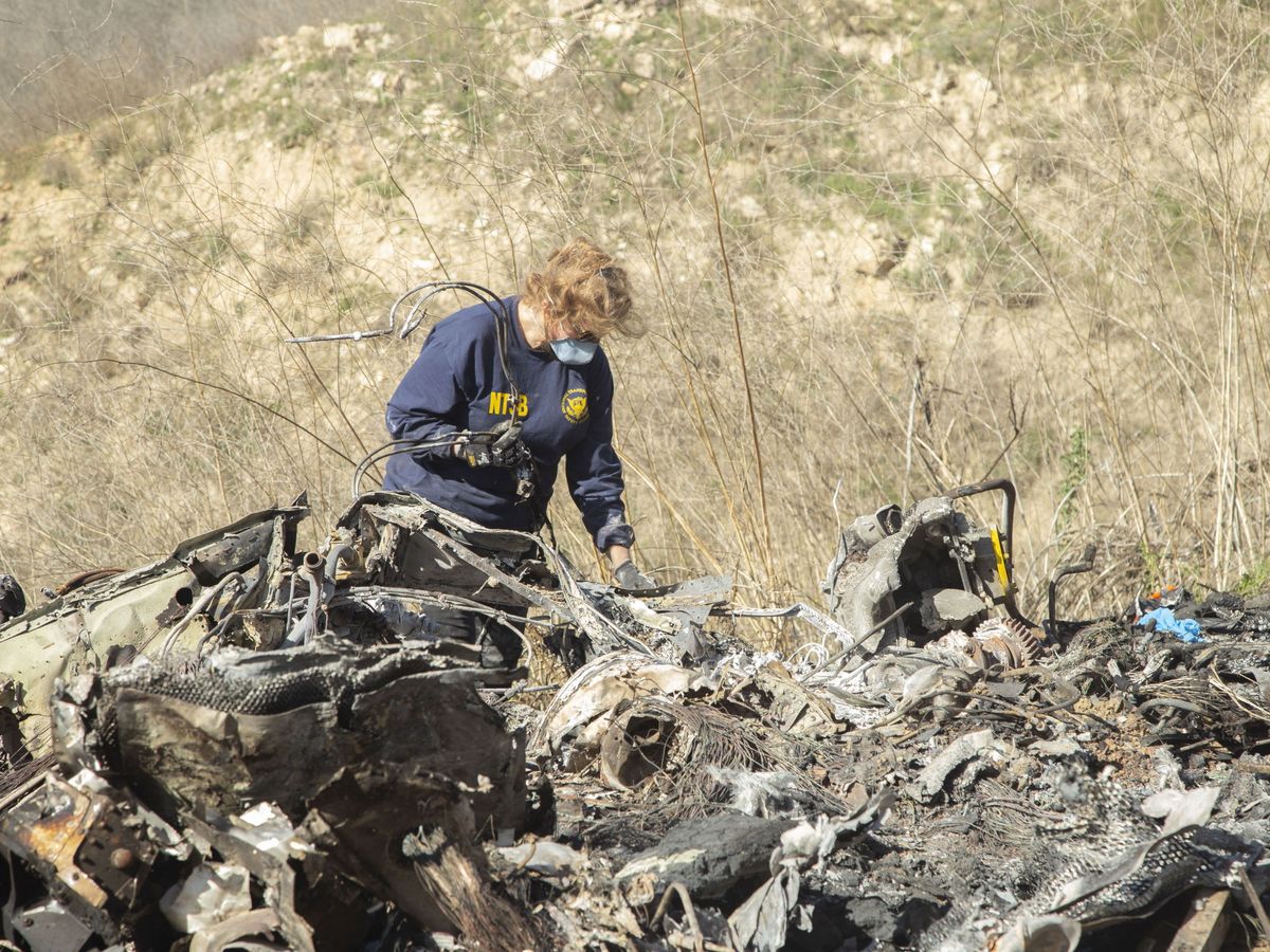 Foto: Una investigadora de la NTSB ante los restos del helicóptero siniestrado. (EFE)