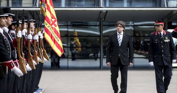 Foto: El presidente de la Generalitat, Carles Puigdemont (i), pasa revista durante la inauguración en la sede central de los Mossos d'Esquadra de un monolito conmemorativo. (EFE)