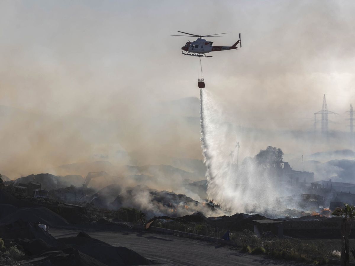 Foto: Un helicóptero del Gobierno de Canarias vierte agua sobre el incendio declarado el jueves en una planta de compostaje de Arona, en el sur de Tenerife. (EFE/Miguel Barreto)