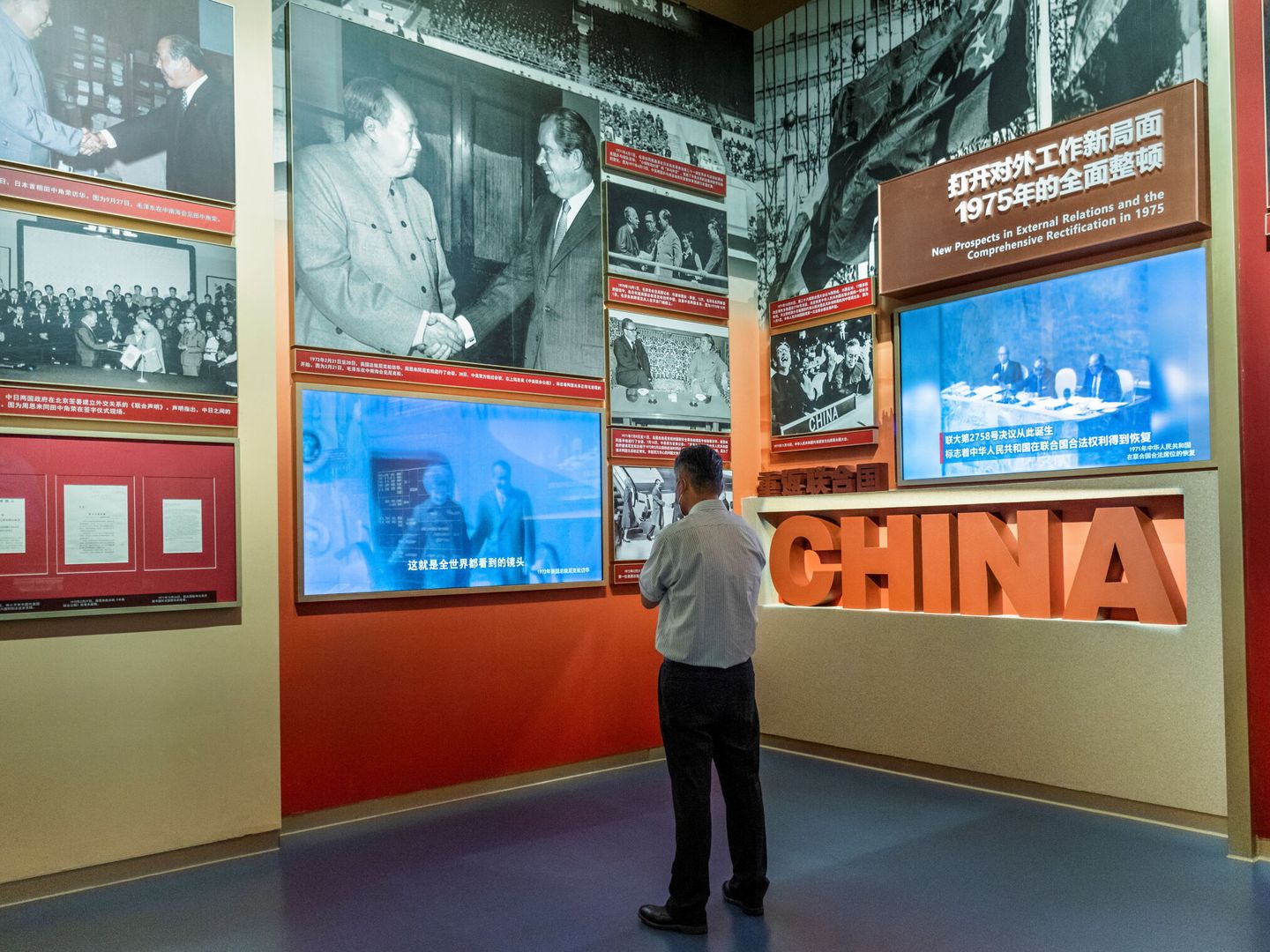 Un hombre contempla imágenes del encuentro entre Richard Nixon y Mao Zedong en el Museo del Partido Comunista en Beiging. (EFE)