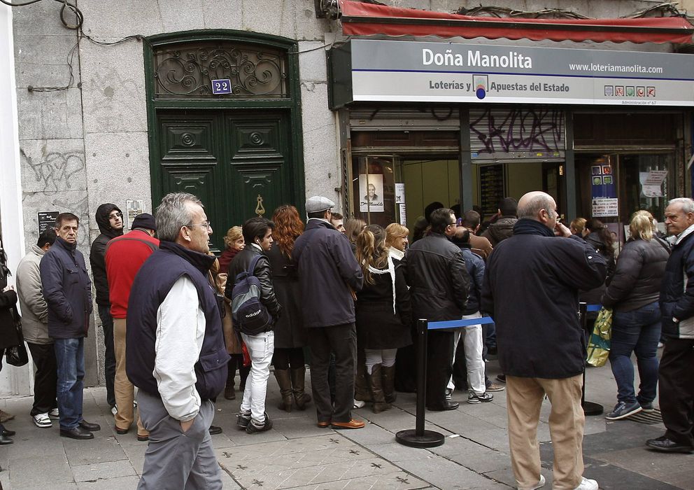 Foto: Decenas de personas esperan su turno ante una administración de lotería en Madrid. (EFE)