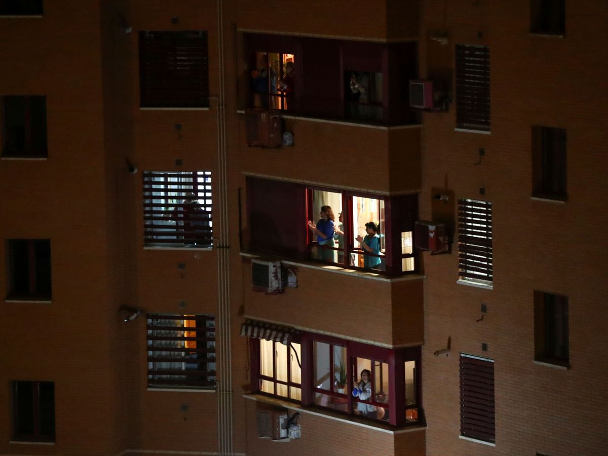 Foto: Vecinos aplaudiendo a la sanidad pública desde sus balcones. (Reuters)