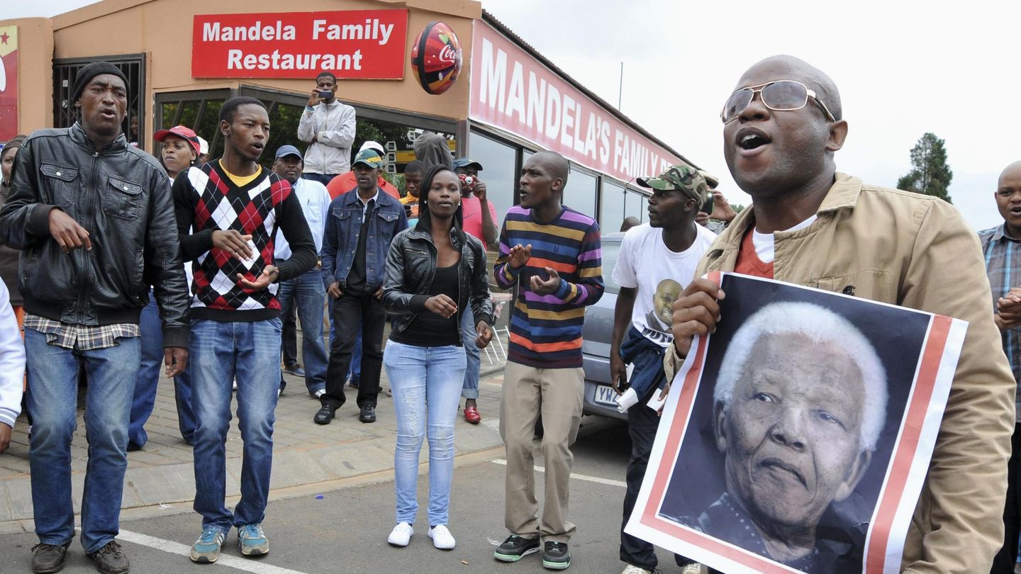 Sudafricanos bailan y cantan en la calle en homenaje a Mandela en Soweto (Reuters).