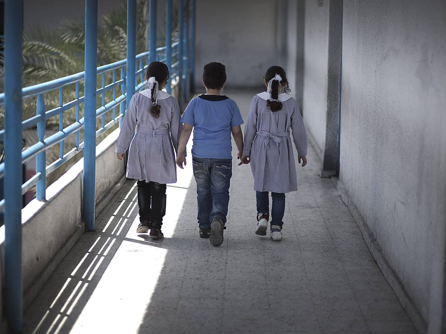 Dos niñas y un niño caminan por un pasillo de su colegio. (EFE)