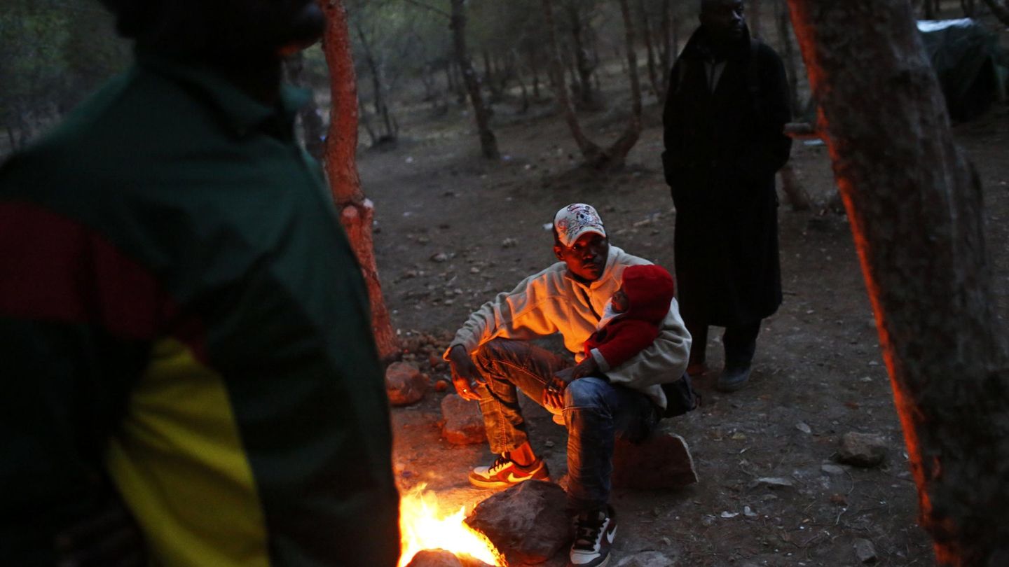 Un subsahariano ante un fuego en un campamento clandestino cerca de la frontera (Reuters).