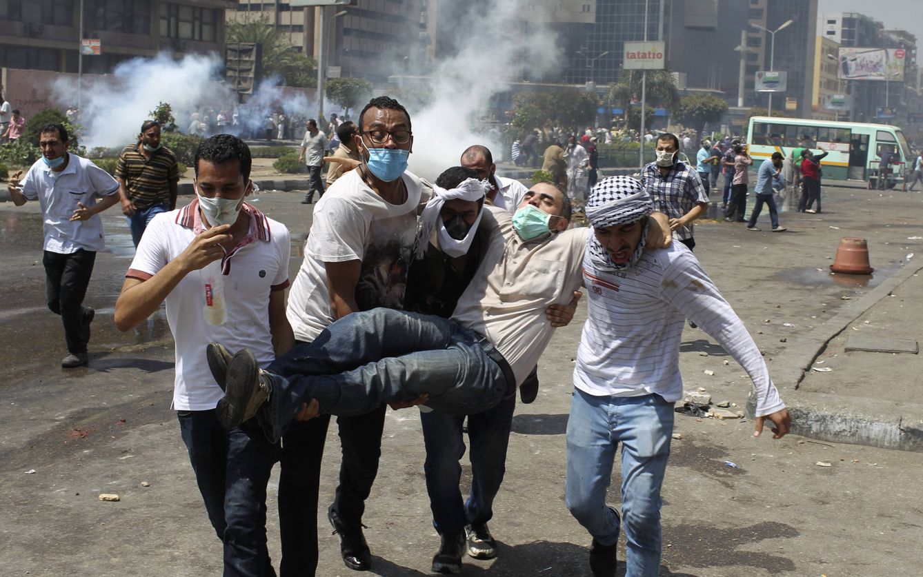 Seguidores del expresidente Mohamed Mursi ayudan a un herido durante enfrentamientos en Rabaa Adawiya. (Reuters)