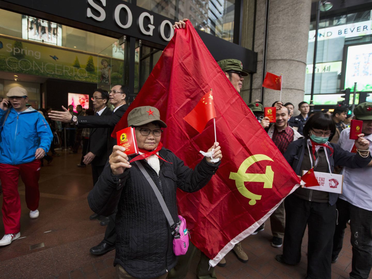 Un manifestante enarbola una copia del Libro Rojo de Mao durante una protesta frente a un centro comercial en Hong Kong, en marzo de 2014. (Reuters)