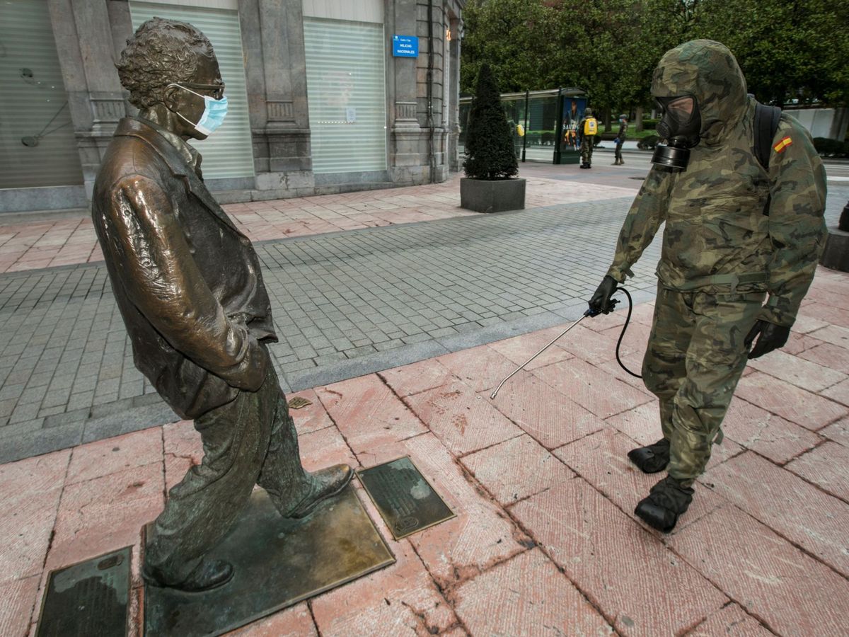 Foto: Un soldado desinfecta la estatua de Woody Allen, con mascarilla, en Oviedo. (EFE)