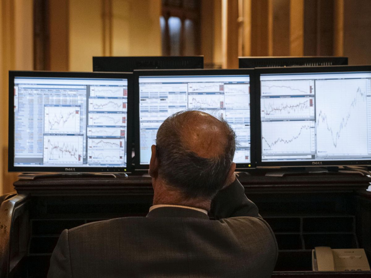 Foto: Un inversor frente a las pantallas del Ibex. (Emilio Naranjo/EFE)