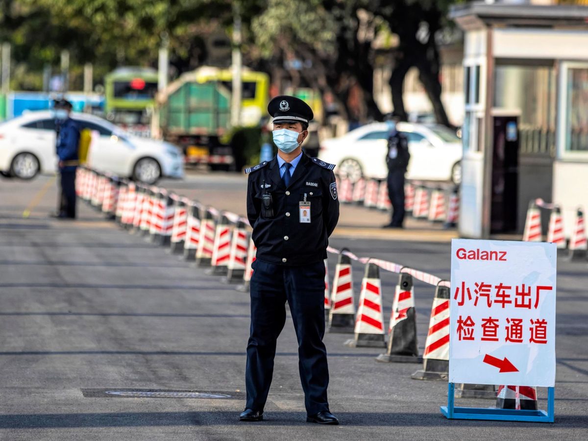 Foto: Un guardia de seguridad protegido con una mascarilla facial en China. (EFE)
