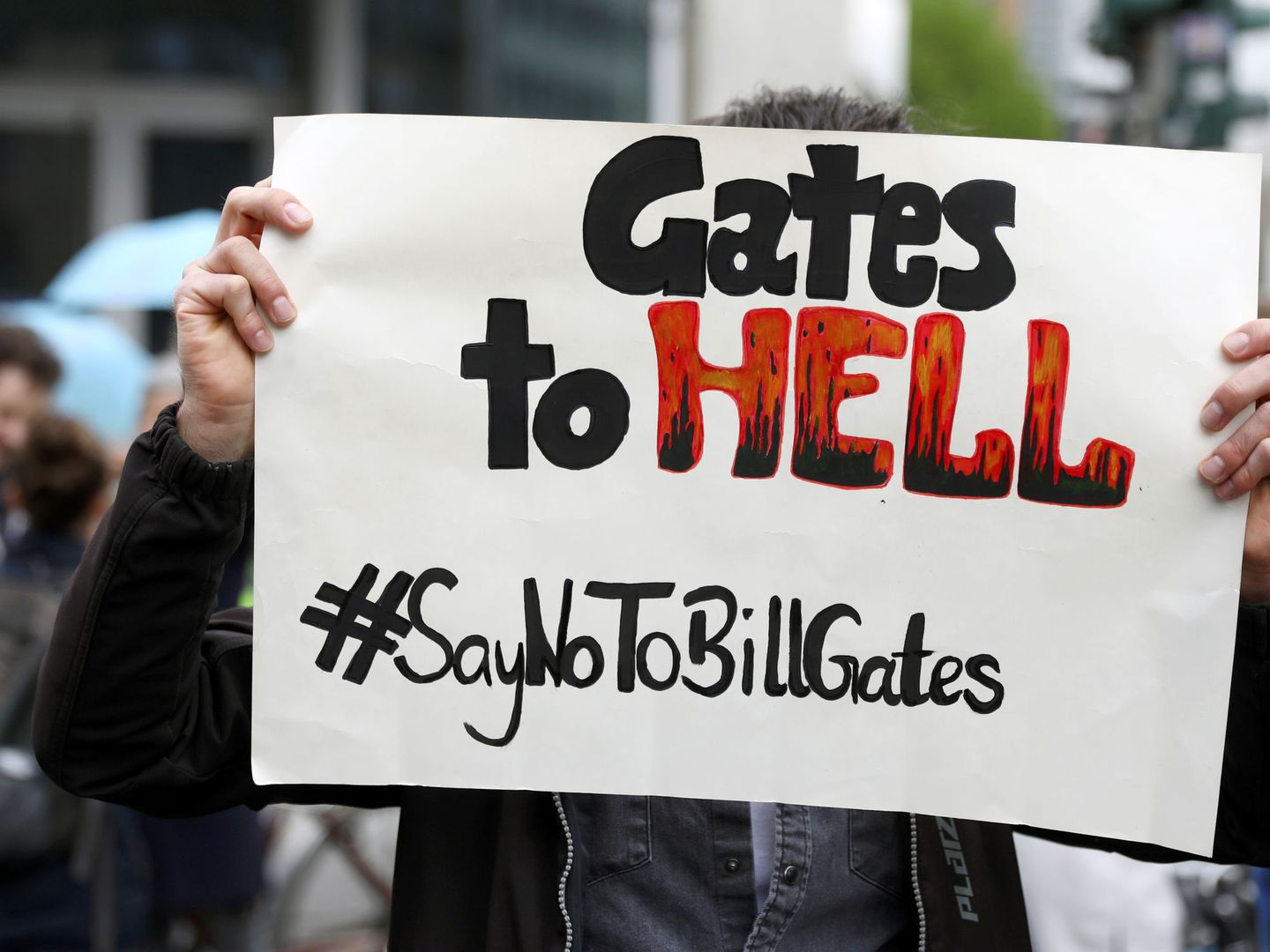A protester holds up a placard with a message against Bill Gates, during a demonstration against the lockdown imposed to slow down the spread of the coronavirus disease (COVID-19), in Berlin, Germany April 25, 2020. REUTERS Christian Mang