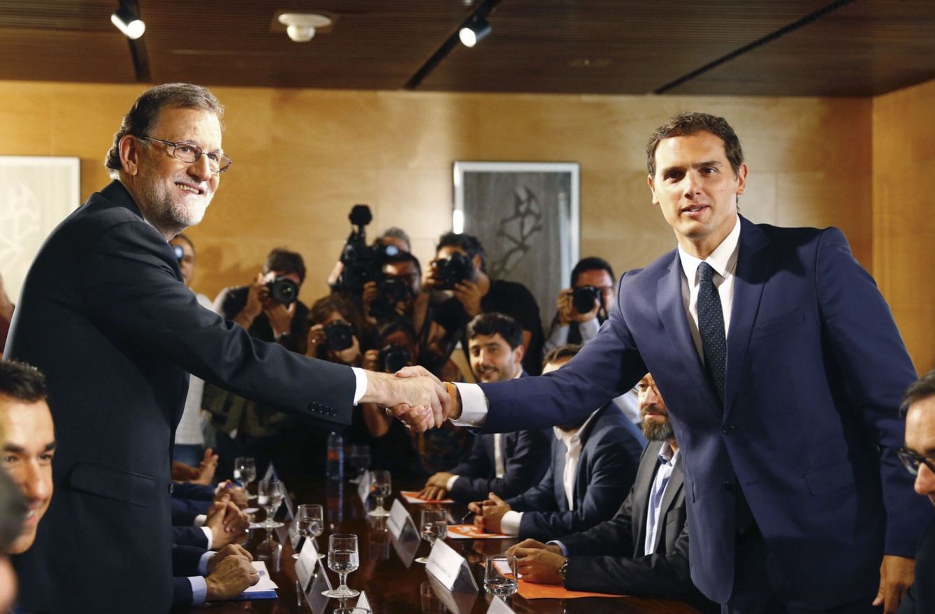 Mariano Rajoy y Albert Rivera se estrechan la mano durante la reunión de sus respectivas delegaciones en la que certificaron el acuerdo de investidura hace un año. (EFE)
