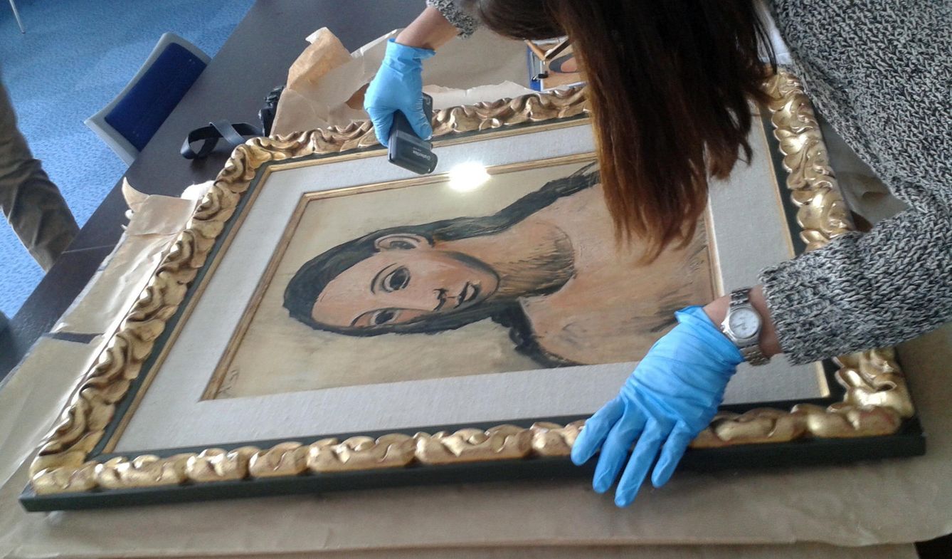 La restauradora del Reina Sofía revisa el estado de la pintura. (EFE)