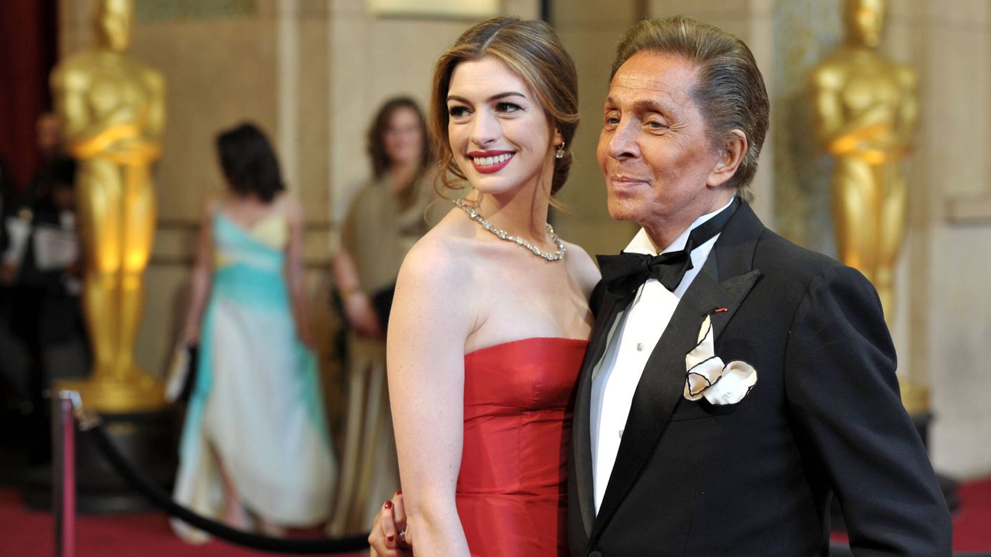 El diseñador Valentino Garavani junto a Anne Hathaway, que luce un vestido en color rojo. (Getty Images)