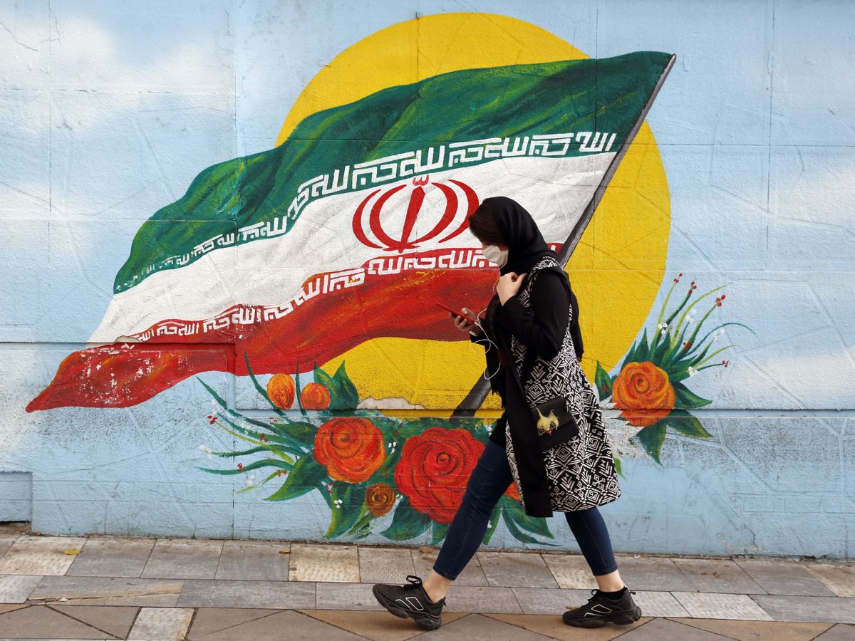Foto: Una mujer pasa delante de un grafiti en Irán. (EFE)