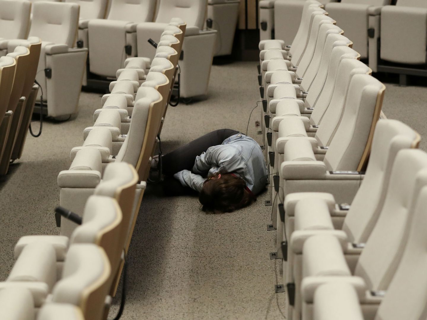 Un corresponsal duerme en el suelo de la sala de prensa del Consejo durante una cumbre. (Reuters)