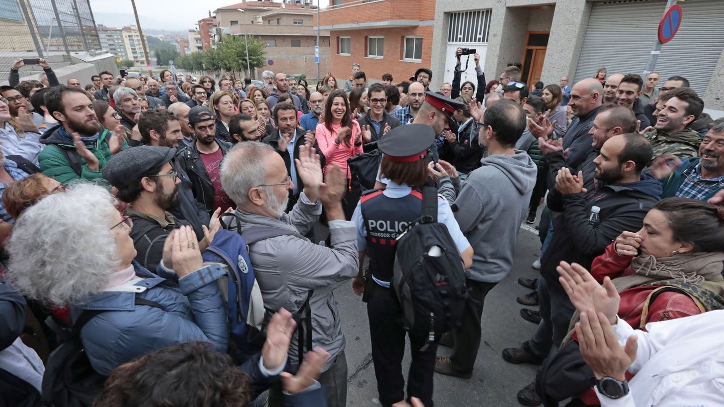Personas que hacen cola ante el IES Montbui, de Santa Margarida de Montbui (Barcelona), para votar con la presencia de un mosso. (EFE)
