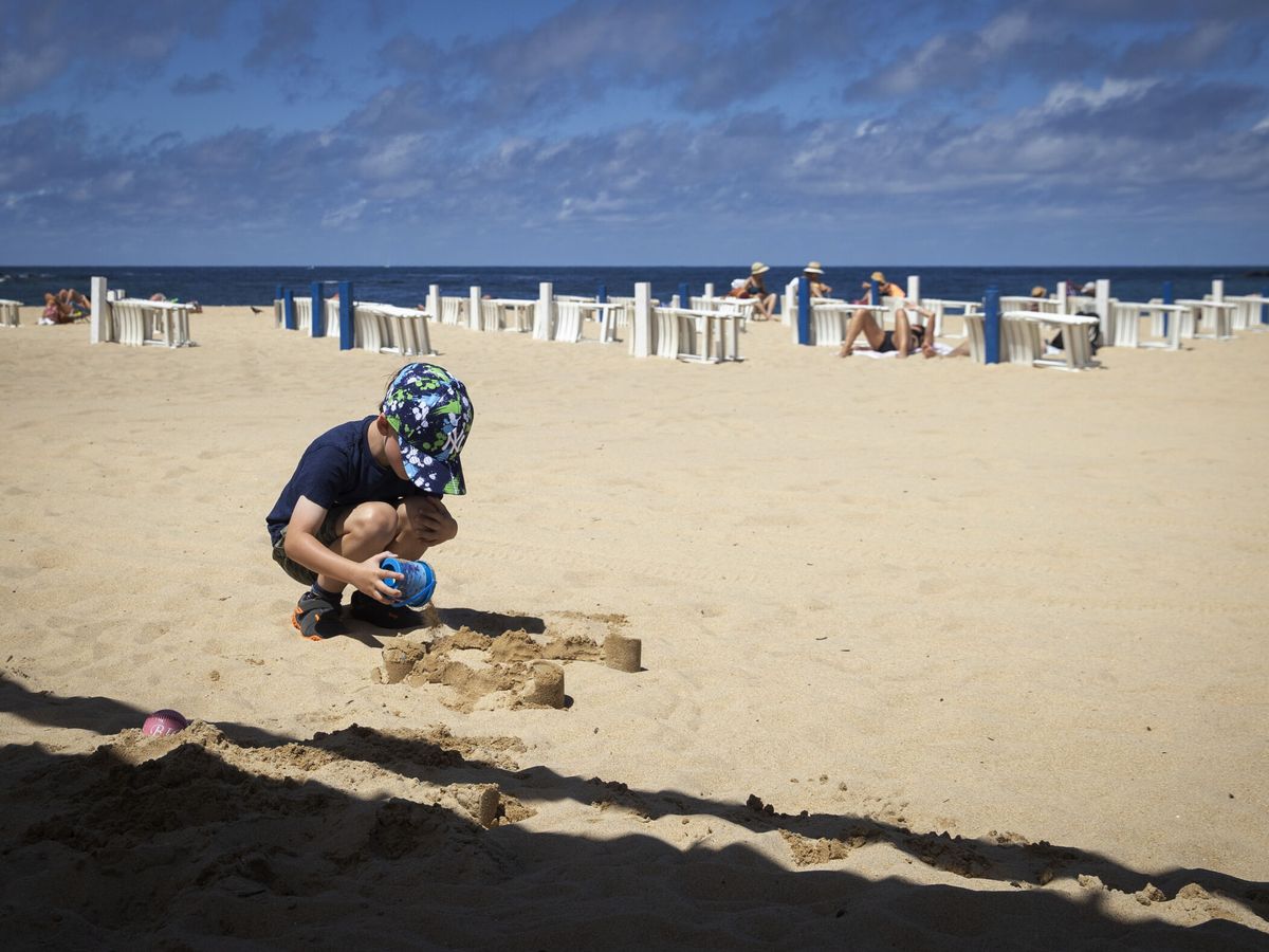 Foto: Un niño juega con la arena en la playa de Ondarreta de San Sebastián. (EFE/Javier Etxezarreta)