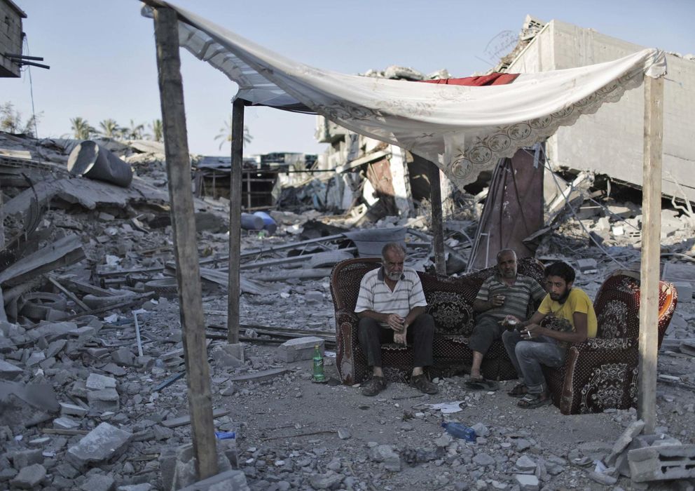 Foto: Palestinos sentados entre los escombros en Gaza. (Reuters)