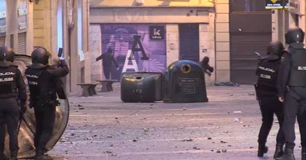 Foto: Los encapuchados lanzan objetos a la Policía en Pamplona. (YouTube)