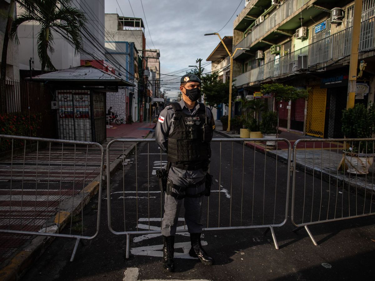 Foto: Un policía hace guardia frente a una calle comercial cerrada en Manaos (Brasil). (EFE)