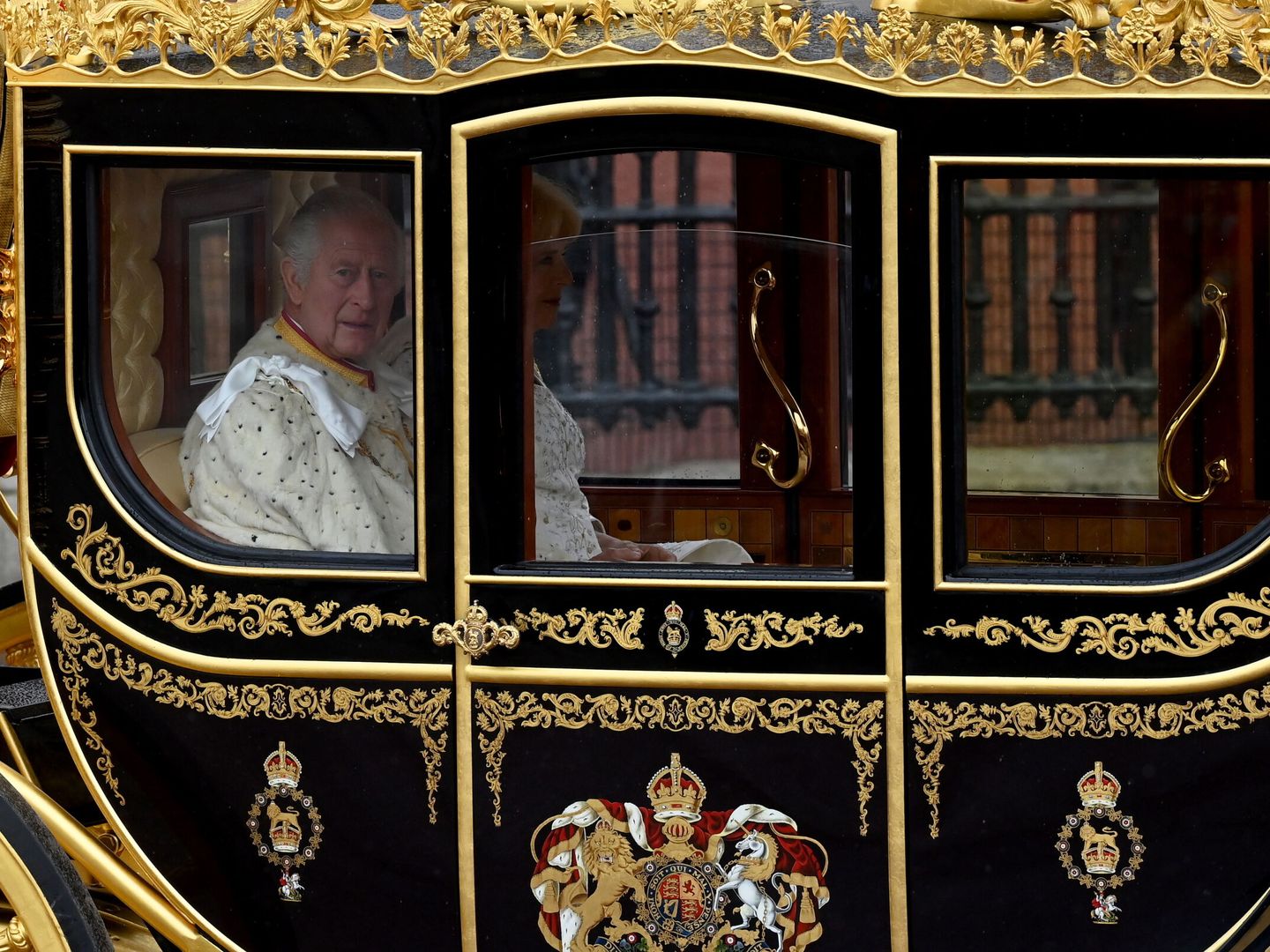 El rey Carlos III y la reina Camila abandonan el palacio de Buckingham en la carroza real, camino a la abadía de Westminster con motivo de la ceremonia de coronación este sábado. (EFE/Neil Hall) 