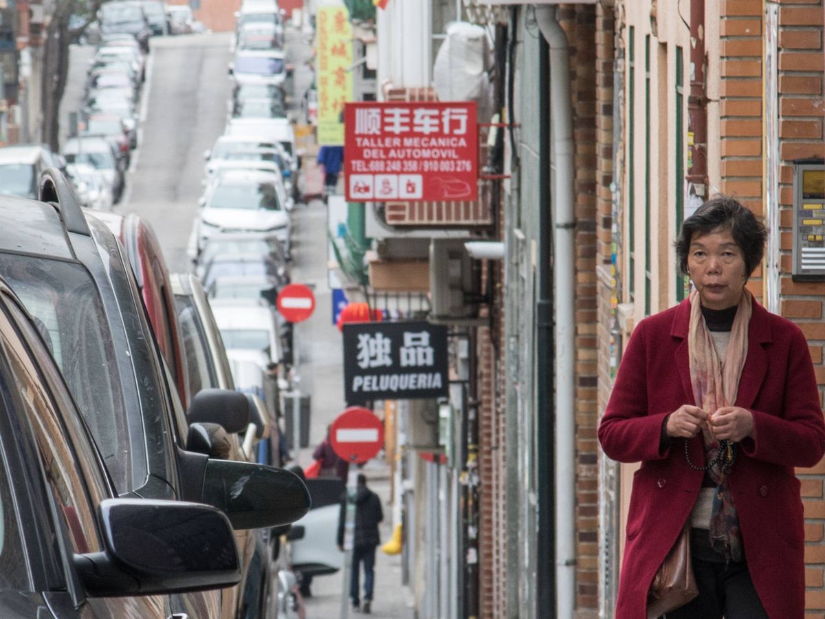 Foto: Una mujer camino por una calle del barrio de Usera, lleno de negocios chinos. (David Brunat)