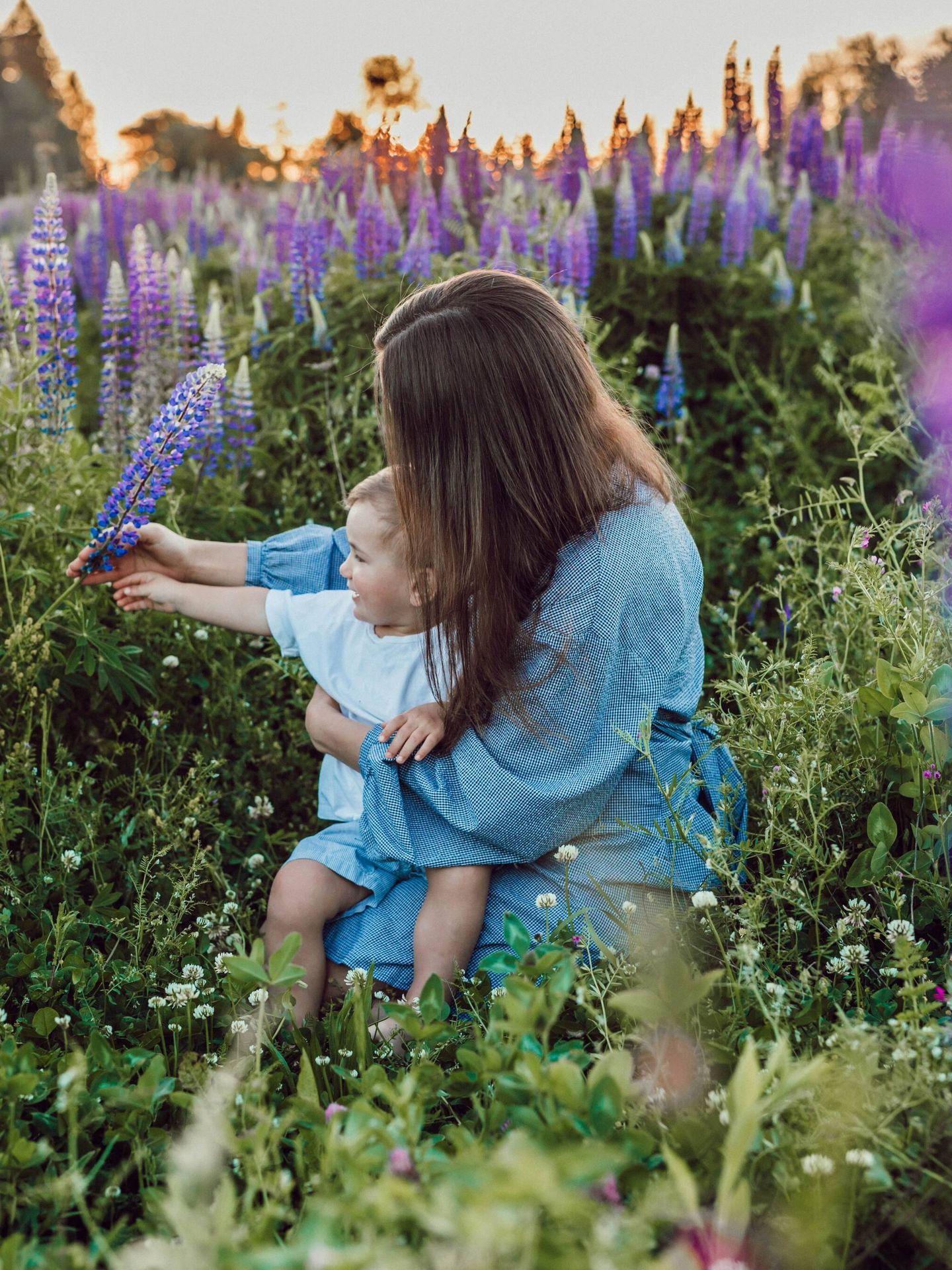Una madre distrayendo a su hijo con unas flores. (Unsplash/Liana Mikah)