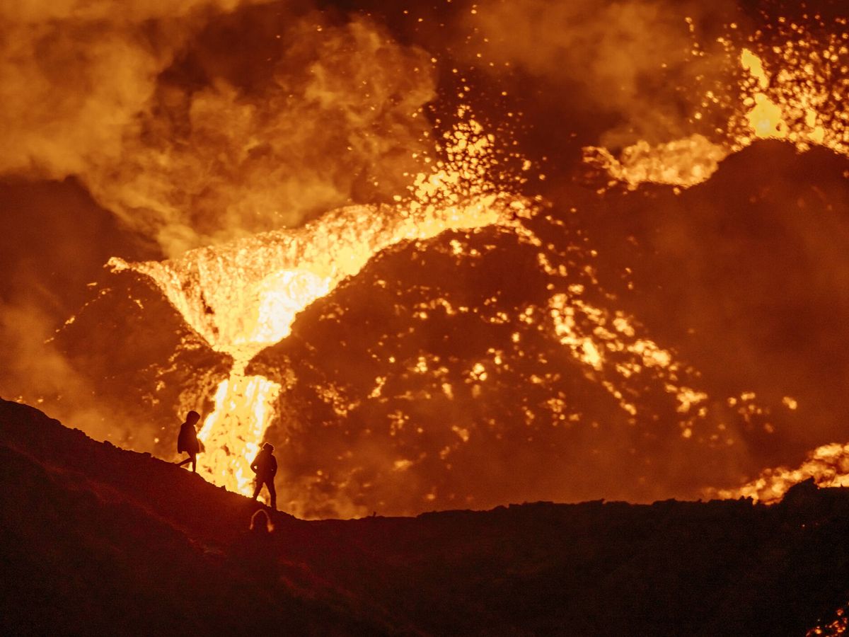 Foto: El volcán Fagradalsjall erupciona y dos personas lo ven. (iStock)