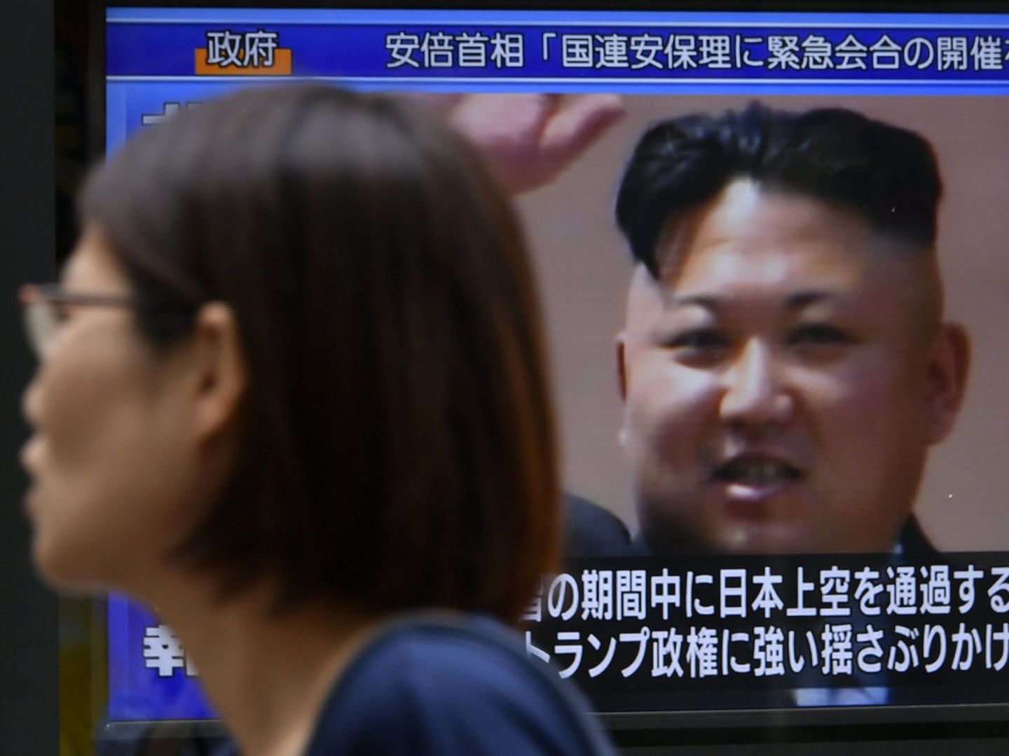 Una mujer pasea en Tokio frente a una pantalla de televisión que muestra a Kim Jong-un. (EFE)