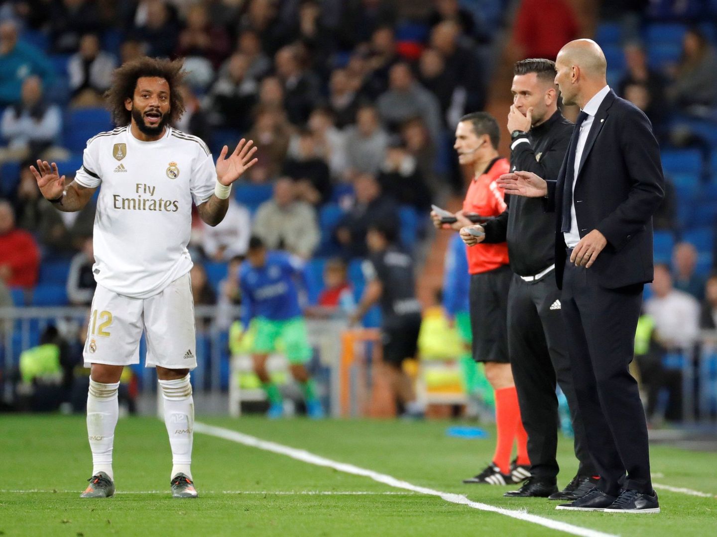 Marcelo y Zidane hablan en la banda durante un partido del Real Madrid. (Efe)