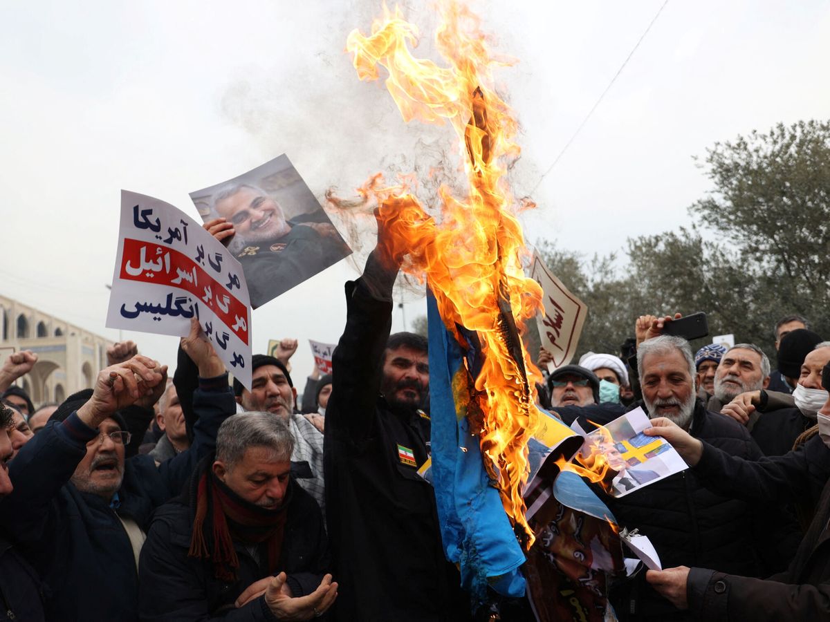 Foto: Manifestantes iraníes queman una bandera sueca en una protesta contra la "desecración" del Corán, en Teherán. (Reuters/Majid Asgaripour)