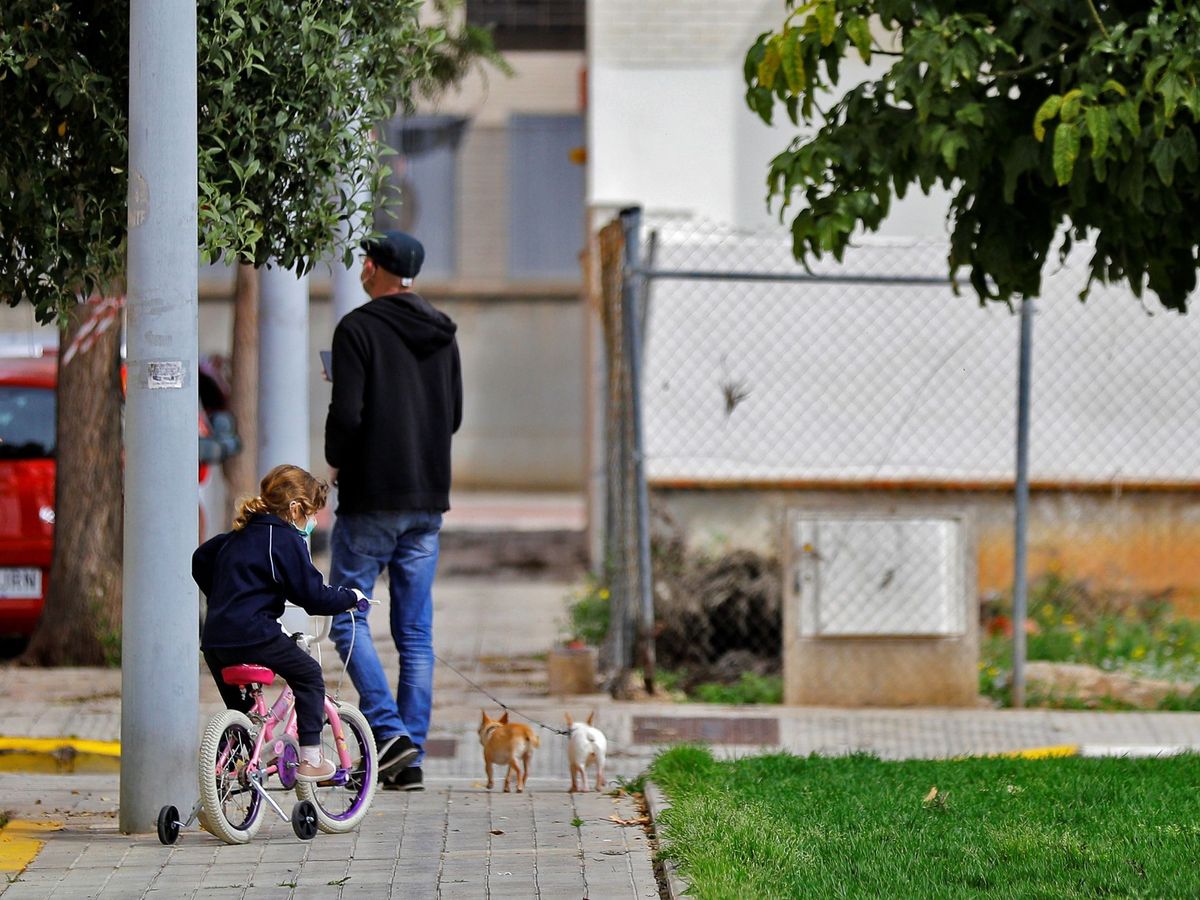 Foto: Un padre junto a su hija y dos perros, en Sevilla. (EFE) 