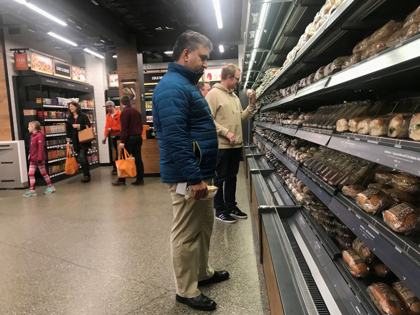 Clientes indecisos entre los wraps, sándwiches y ensaladas preparadas en un supermercado. (Reuters)
