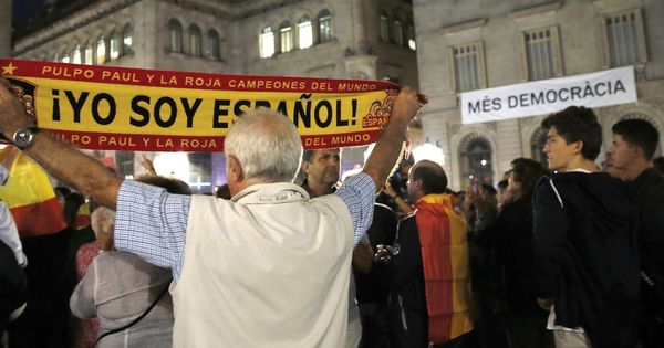 Foto: Un hombre sostiene una bandera con el lema 'Yo soy español' en Barcelona. (EFE)