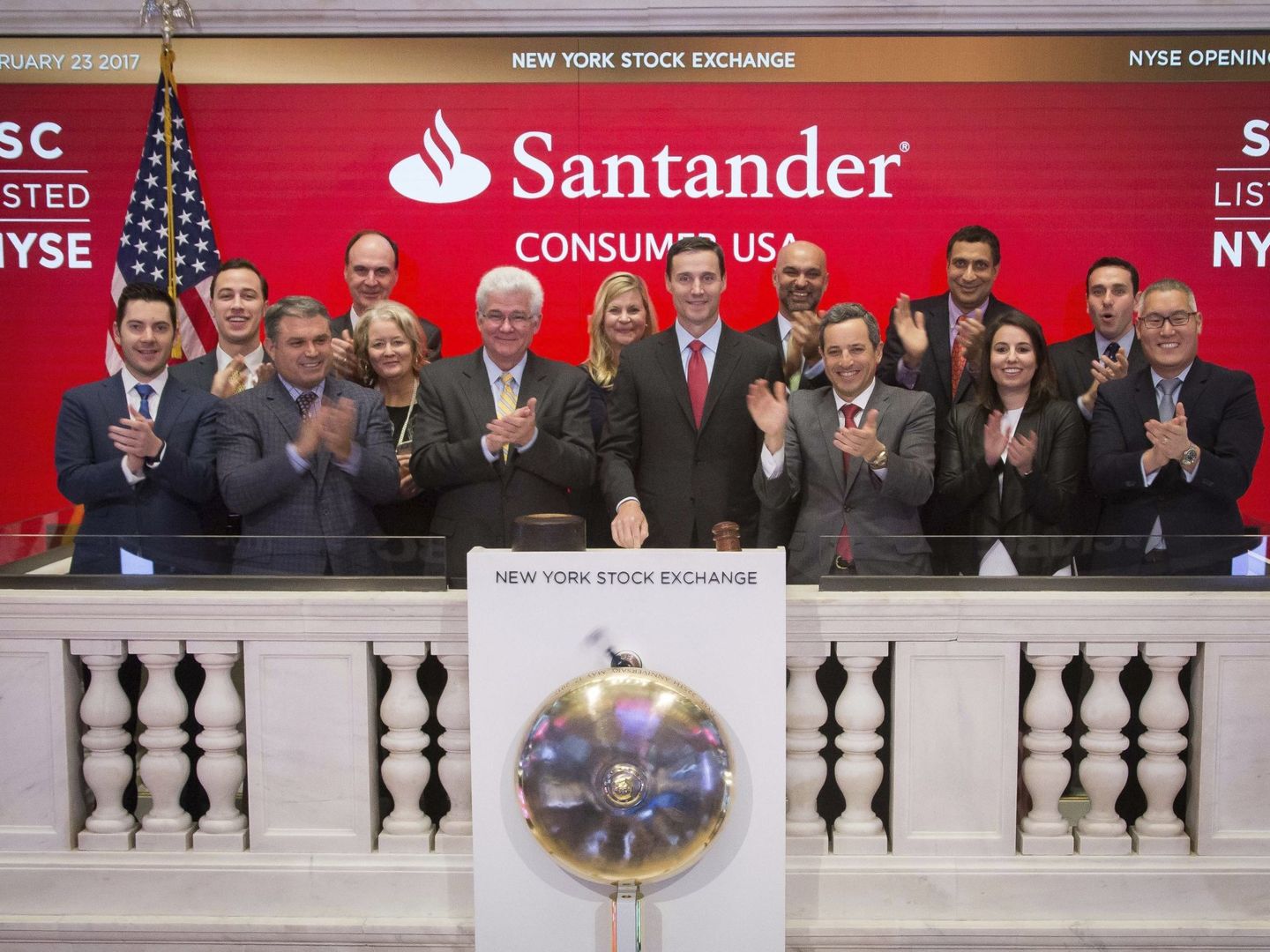 El presidente de Santander Consumer Finance, Jason Kulas (c), abre la sesión de Wall St. el 23 de febrero.