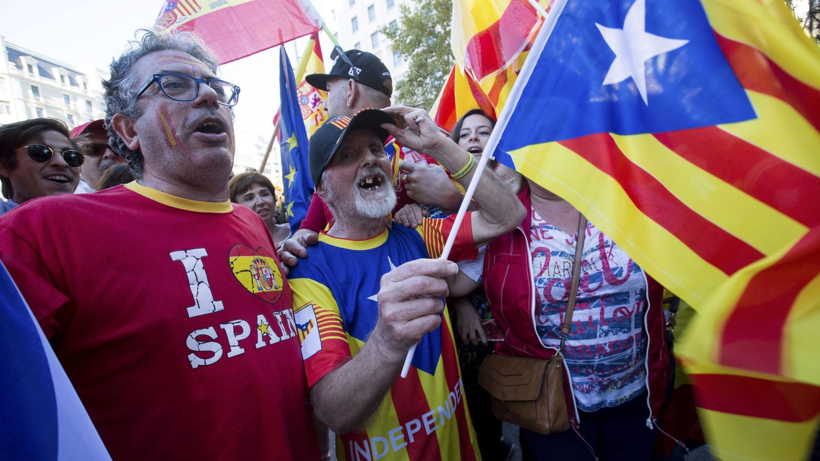 Foto: Un hombre con una bandera independentista (c), junto a otros con banderas españolas. (EFE)
