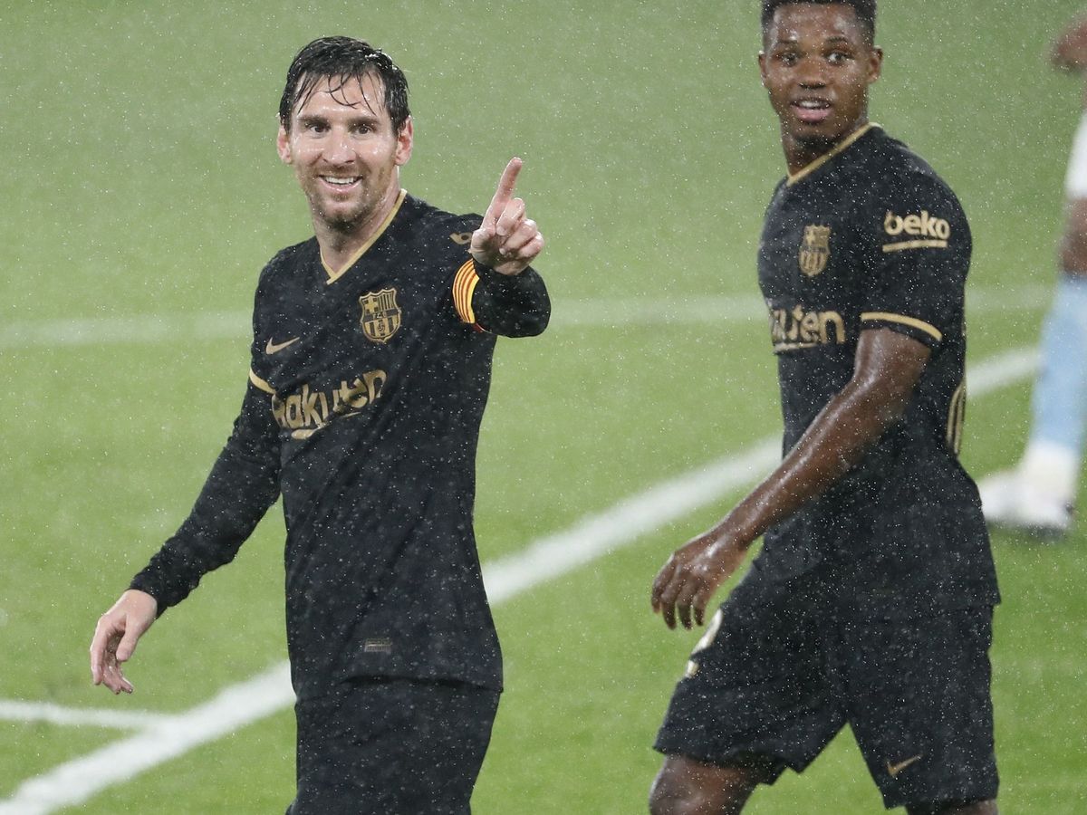 Foto: Leo Messi y Ansu Fati, durante el partido, bajo la lluvia. (EFE)
