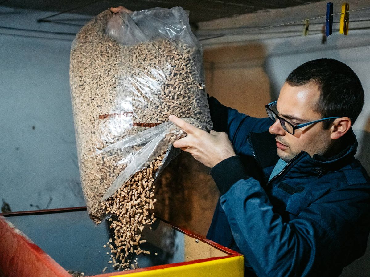 Foto: Un hombre alimenta una caldera de pellets. (Getty/Urbazon)