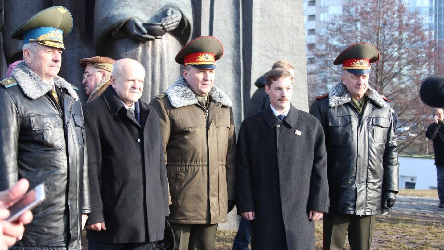 Albert Santin, segundo por la derecha, posa con cuadros del régimen bielorruso en Minsk.