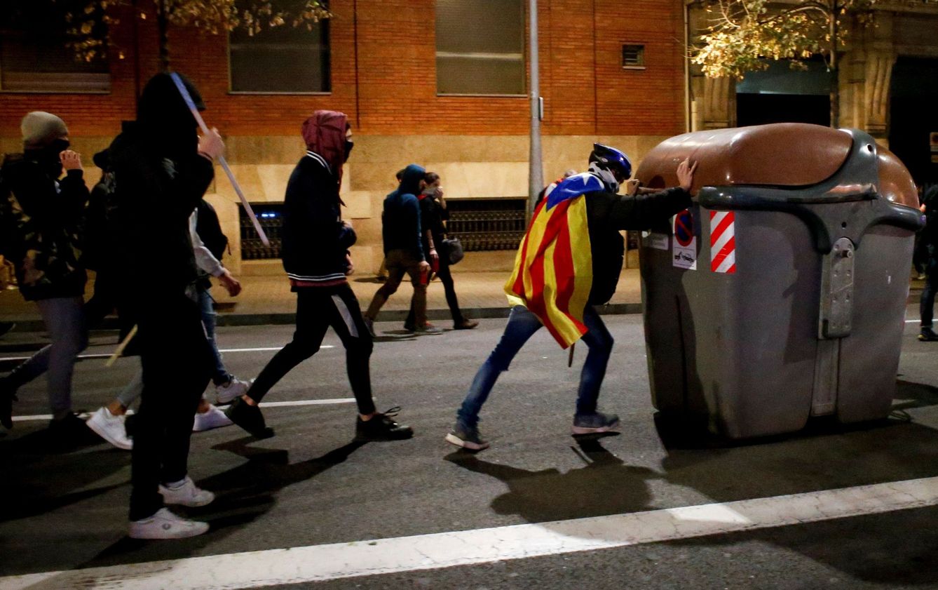  Radicales independentistas preparan una barricada en el centro de Barcelona. (EFE)