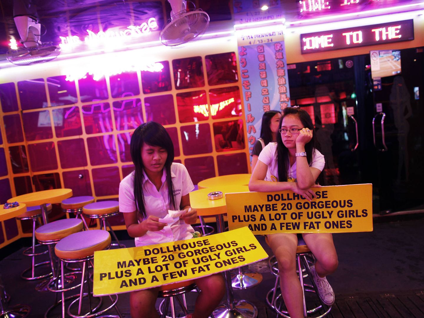 Dos chicas esperan a clientes en un bar de Soi Cowboy, una calle de Bangkok famosa por sus clubs de alterne. (Reuters)
